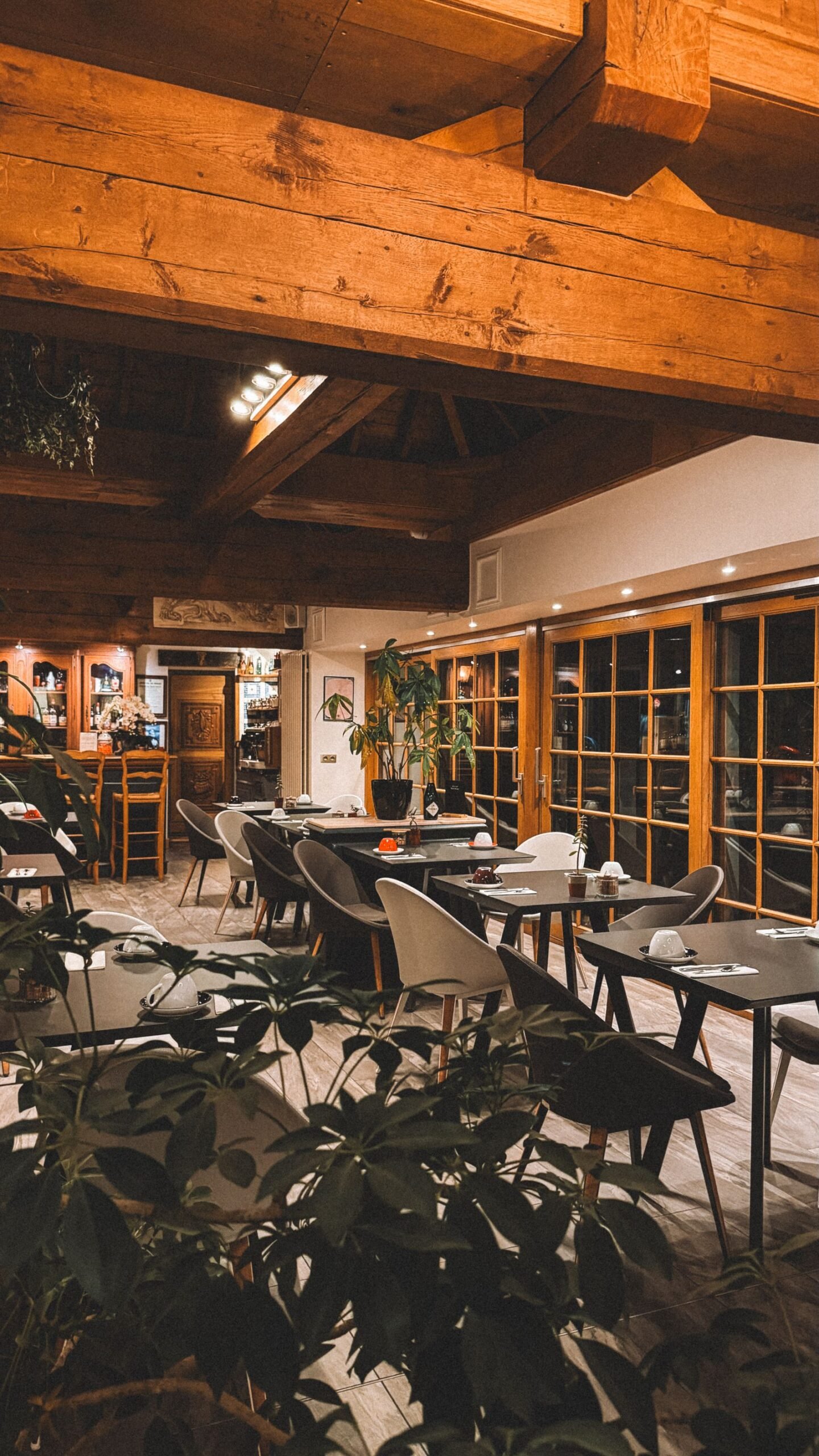 Interior acogedor de un restaurante con vigas de madera y mesas puestas
